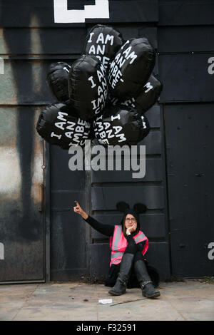 Un molto stanco e scontroso park attendant con palloncini di souvenir da David Shrigley. Foto Stock