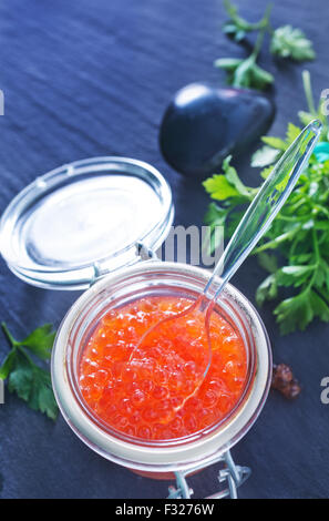 Rosso Salmone caviale in banca di vetro e su un tavolo Foto Stock