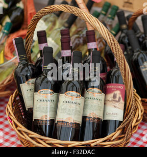 Cesto di vino Chianti Bottiglie su un rosso a scacchi tabella panno all'outdoor Campo de Fiori Mercato, Roma Foto Stock
