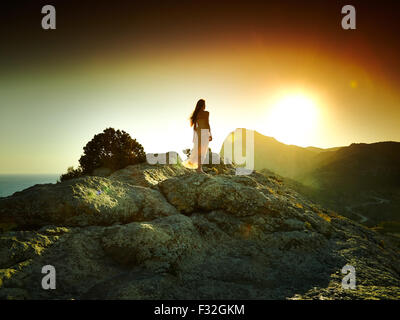 Silhouette di donna al tramonto in montagna. Paesaggio Crimea Foto Stock