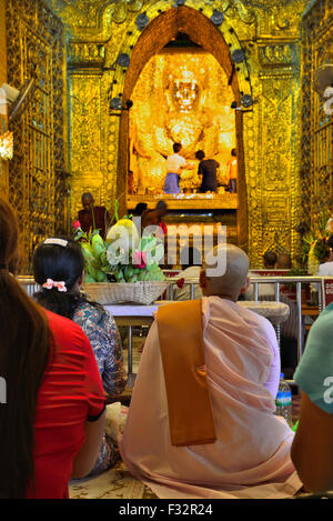 Suora birmana e fedeli al famoso Buddha d'oro presso il Tempio Mahamuni, Mandalay City, Myanmar (Birmania, Birmania) Asia Foto Stock