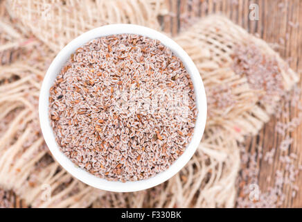 Psillio semi in una ciotola (close-up shot) su sfondo di legno Foto Stock