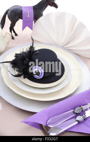 Horse Racing Ladies pranzo raffinato impostazione tabella con piccolo nero fascinator hat, decorazioni e champagne. Foto Stock