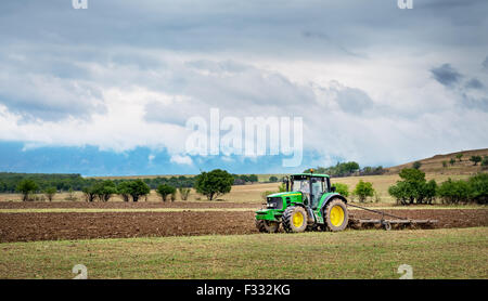 Karlovo, Bulgaria - Agosto 22th, 2015: aratura di un campo con John Deere trattore 6930. John Deere 8100 è stato fabbricato nel 1995- Foto Stock