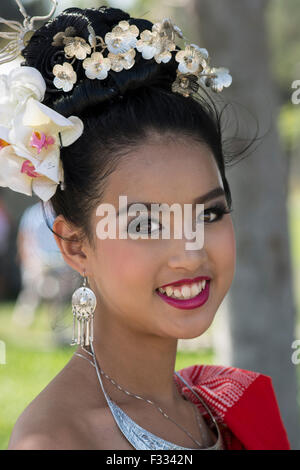 Una giovane ragazza tailandese vestito in tailandese tradizionale abito, posa dopo uno spettacolo di danza a Irvine Global Village Festival Foto Stock