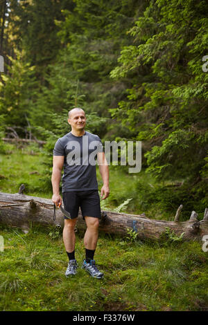 Montare uomo caucasico con un machete in procinto di fare il camp in una foresta di conifere Foto Stock