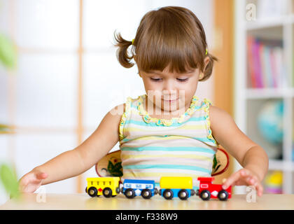 Carino kid girl riproduzione di treni di legno toy Foto Stock