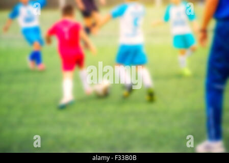 Ragazzi che giocano a calcio, defocussed blur sport immagine di sfondo Foto Stock