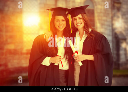 Immagine composita di due donne che abbraccia ogni altro dopo che si è laureato dall'università Foto Stock