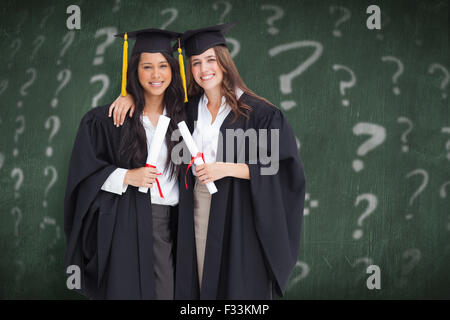 Immagine composita di due donne che abbraccia ogni altro dopo che si è laureato dall'università Foto Stock