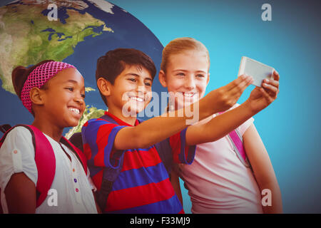 Immagine composita di felice kids tenendo selfie nel corridoio della scuola Foto Stock