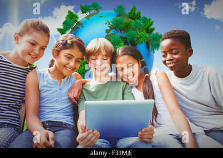 Immagine composita di bambini felici con tavoletta digitale presso il park Foto Stock