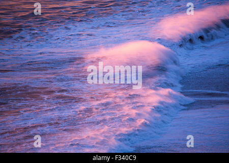 Onde che si infrangono sulla spiaggia guardando ad ovest da Dyrhólaey al crepuscolo, Islanda Foto Stock