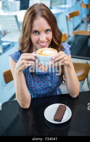 Bella bruna con caffè e torta Foto Stock