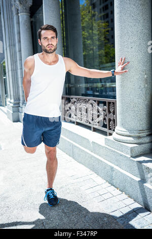 Bello atleta gamba facendo stretching Foto Stock