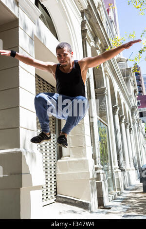 Uomo che fa parkour in città Foto Stock