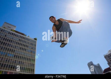 Uomo che fa parkour in città Foto Stock