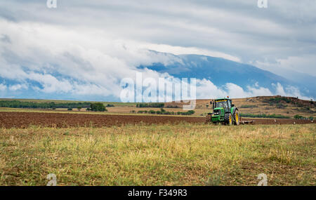 Karlovo, Bulgaria - Agosto 22th, 2015: aratura di un campo con John Deere trattore 6930. John Deere 8100 è stato fabbricato nel 1995- Foto Stock