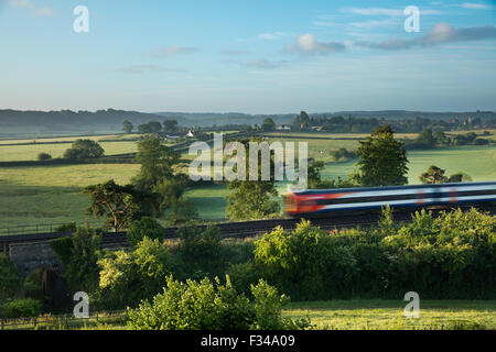 Il London Waterloo a Exeter treno passa Milborne stoppino in una nebbiosa mattina d'estate, Somerset, Inghilterra, Regno Unito Foto Stock