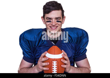 Sorridente giocatore di football americano tenendo una palla Foto Stock