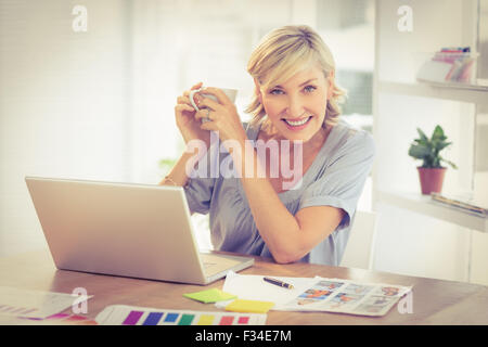 Imprenditrice sorridente al lavoro su un notebook Foto Stock