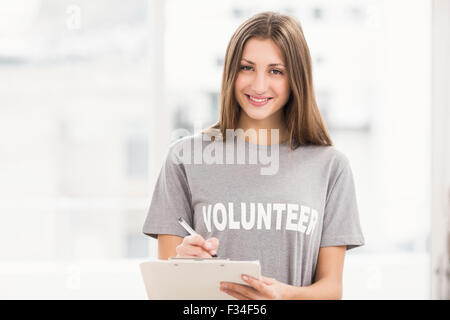 Sorridente brunette volontario con appunti Foto Stock