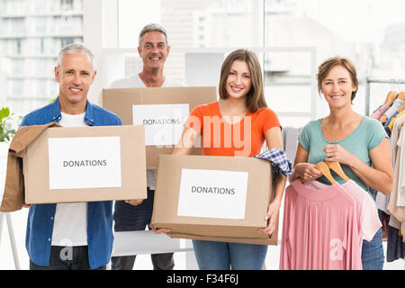 Sorridente informali di lavoro Persone con scatole di donazione Foto Stock