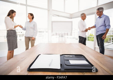 Planner davanti di handshaking la gente di affari Foto Stock