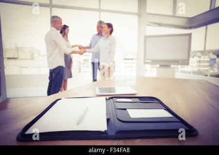 Planner davanti di handshaking la gente di affari Foto Stock