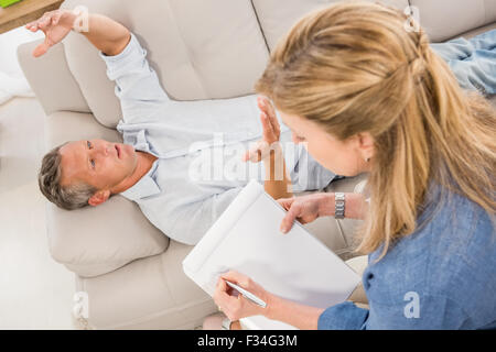 Premuto uomo disteso sul lettino e parlare al terapista Foto Stock