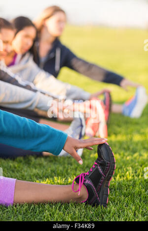 Sportivo da donna lo stiramento durante la lezione di fitness Foto Stock