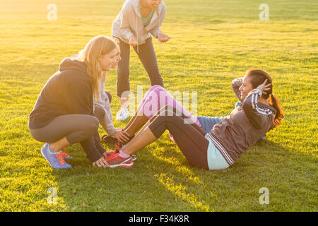 Donne sportivo facendo sit ups durante la lezione di fitness Foto Stock