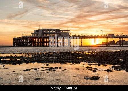 Worthing Pier a bassa marea e del tramonto sulla costa sud dell'Inghilterra nel West Sussex. Foto Stock