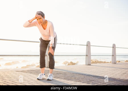 Sudorazione sportivo da donna appoggiata al promenade Foto Stock