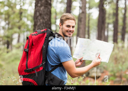 Giovane bello escursionista usando la mappa Foto Stock