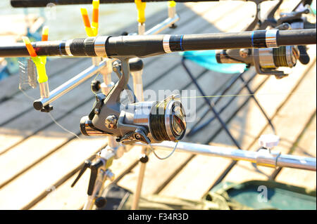 Asta della bobina, la quale è montata sul molo per la pesca in una giornata di sole. Foto Stock