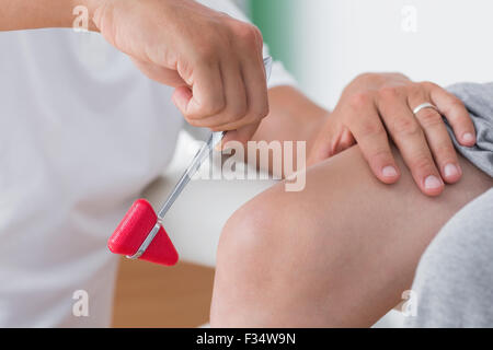 Il controllo medico dei riflessi del ginocchio del suo paziente Foto Stock