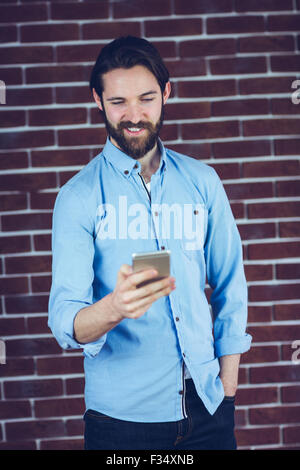 Uomo sorridente utilizza lo smartphone Foto Stock