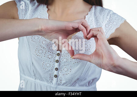 Donna messa a forma di cuore con le mani Foto Stock