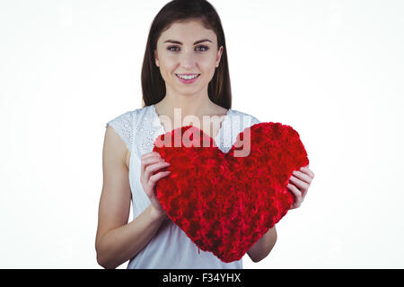 Donna che mantiene la forma di cuore cuscino Foto Stock