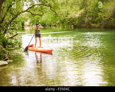 Donna stand up paddle imbarco su Barton Creek, Austin, Texas Foto Stock