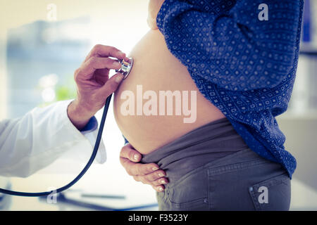 Immagine ritagliata del medico di esaminare la donna incinta in clinica Foto Stock