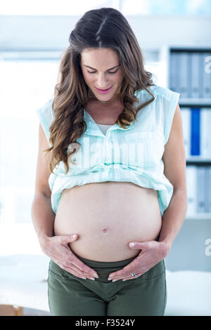 Donna incinta toccando ventre Foto Stock