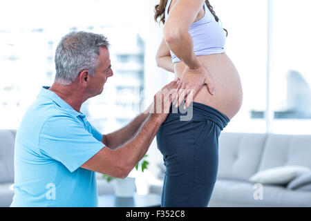 Terapista massaggiatore donna incinta a casa Foto Stock