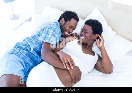 Il marito e la moglie di ridere mentre vi rilassate sul letto Foto Stock