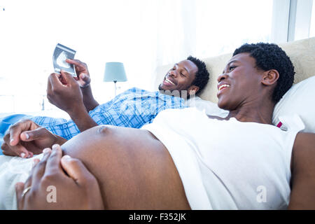 Felice l'uomo che mostra di scansione ad ultrasuoni per donna Foto Stock