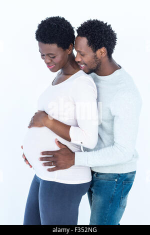 L'uomo abbracciando la sua moglie incinta mentre in piedi Foto Stock