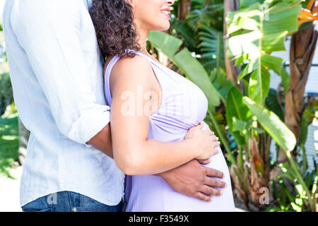 Sezione mediana del marito con moglie incinta toccando ventre Foto Stock