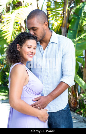 Il marito baciare moglie incinta testa Foto Stock