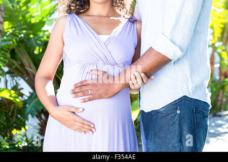 Sezione mediana della moglie incinta con il marito di toccare la pancia Foto Stock